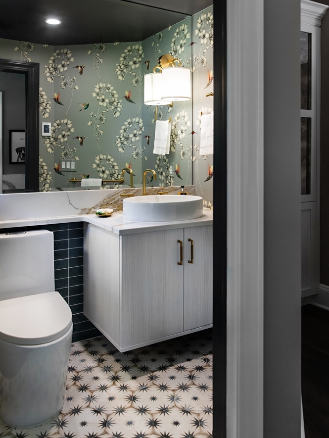 Just off the mud area, the powder room got its own makeover - now boasting a textured white wall mount vanity, a contemporary vessel sink complimented by fun patterns on the walls and floor.